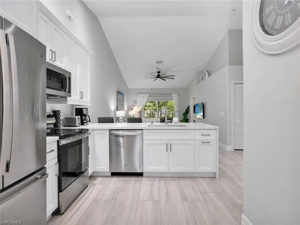 a kitchen with white cabinets and stainless steel appliances