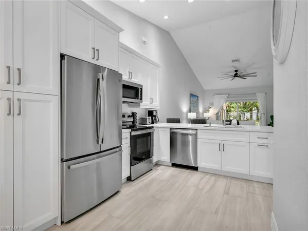a kitchen with cabinets stainless steel appliances and wooden floor