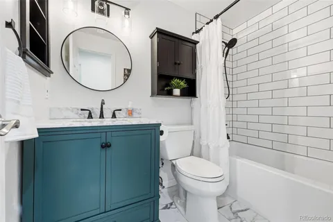 a bathroom with a toilet sink vanity tub and mirror