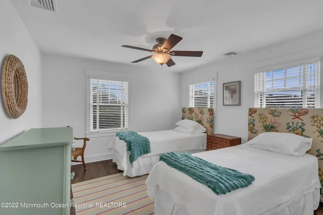 a bedroom with two beds and a potted plant
