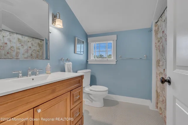 a bathroom with a sink a toilet and mirror
