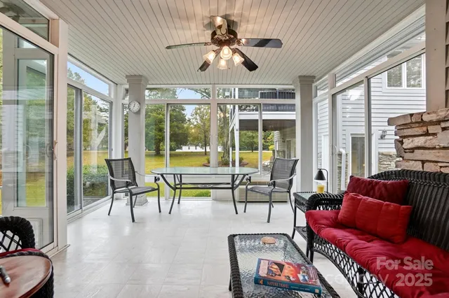 a living room with furniture a fireplace and a floor to ceiling window