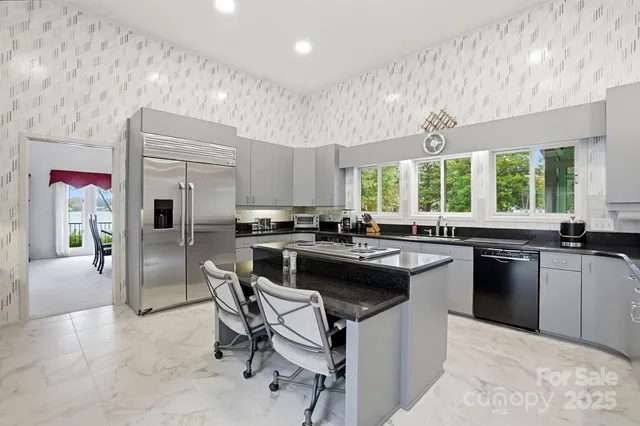 a kitchen with a stove a sink a kitchen island and chairs in it