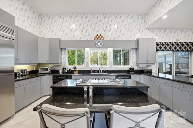 a kitchen with a sink and chairs