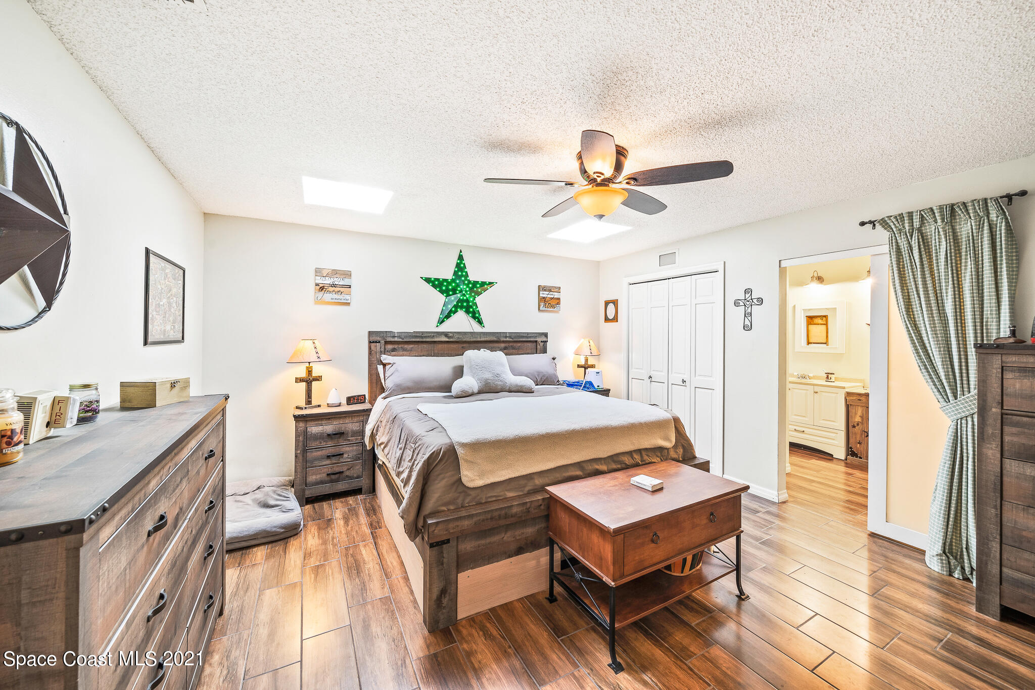 3900 Pinewood Road Melbourne, FL 32934 - Photo 22 of 88 a bedroom with a bed and a chandelier