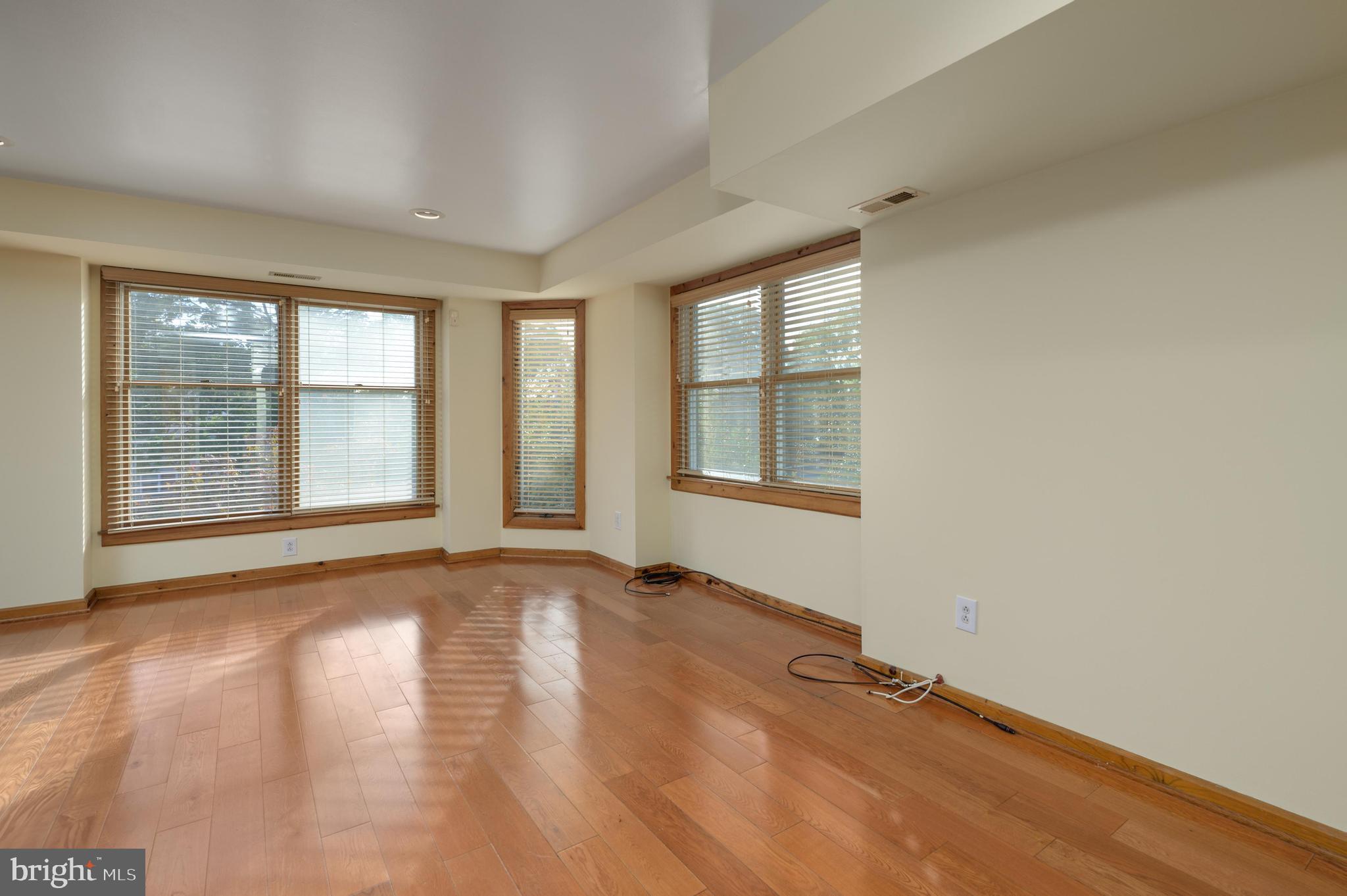23 South Main Street, Unit 3 Medford, NJ 08055 - Photo 4 of 26 an empty room with wooden floor and windows
