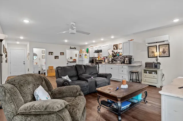 a living room with furniture a rug and kitchen view