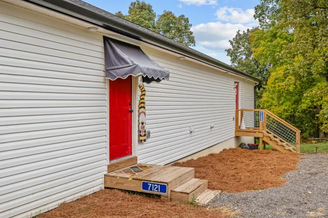 a backyard of a house with wooden fence and large trees