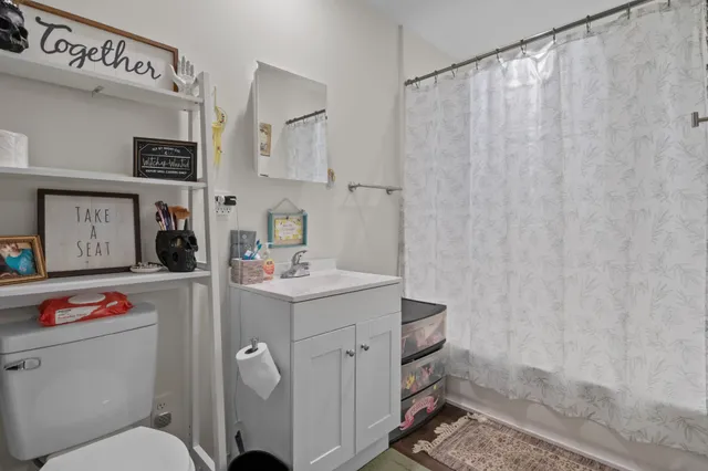 a bathroom with a toilet sink and shower curtain