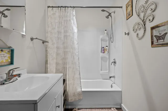 a bathroom with a sink a mirror a bathtub and shower