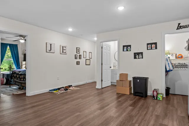 a view of a livingroom with wooden floor and a workspace