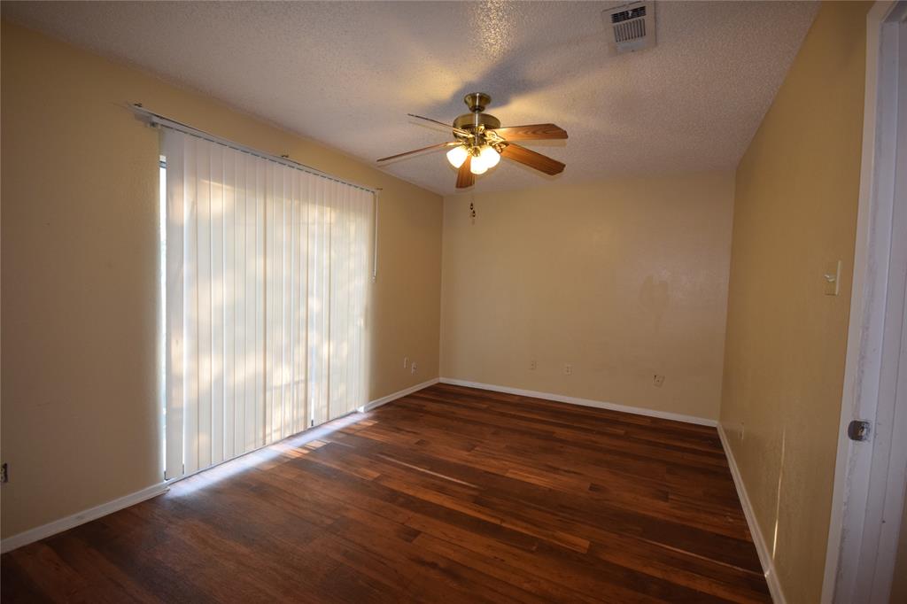 4909 Jamesway Road, Unit 203D Fort Worth, TX 76135 - Photo 12 of 17 a view of empty room with wooden floor and fan