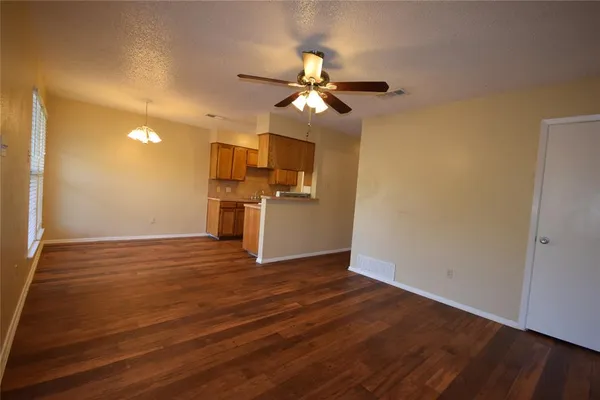 a view of a kitchen with a ceiling fan hardwood floor and a ceiling fan