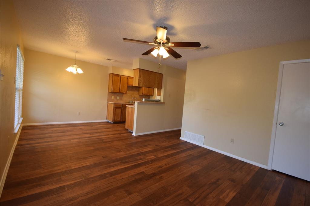 4909 Jamesway Road, Unit 203D Fort Worth, TX 76135 - Photo 3 of 17 a view of a kitchen with a ceiling fan hardwood floor and a ceiling fan