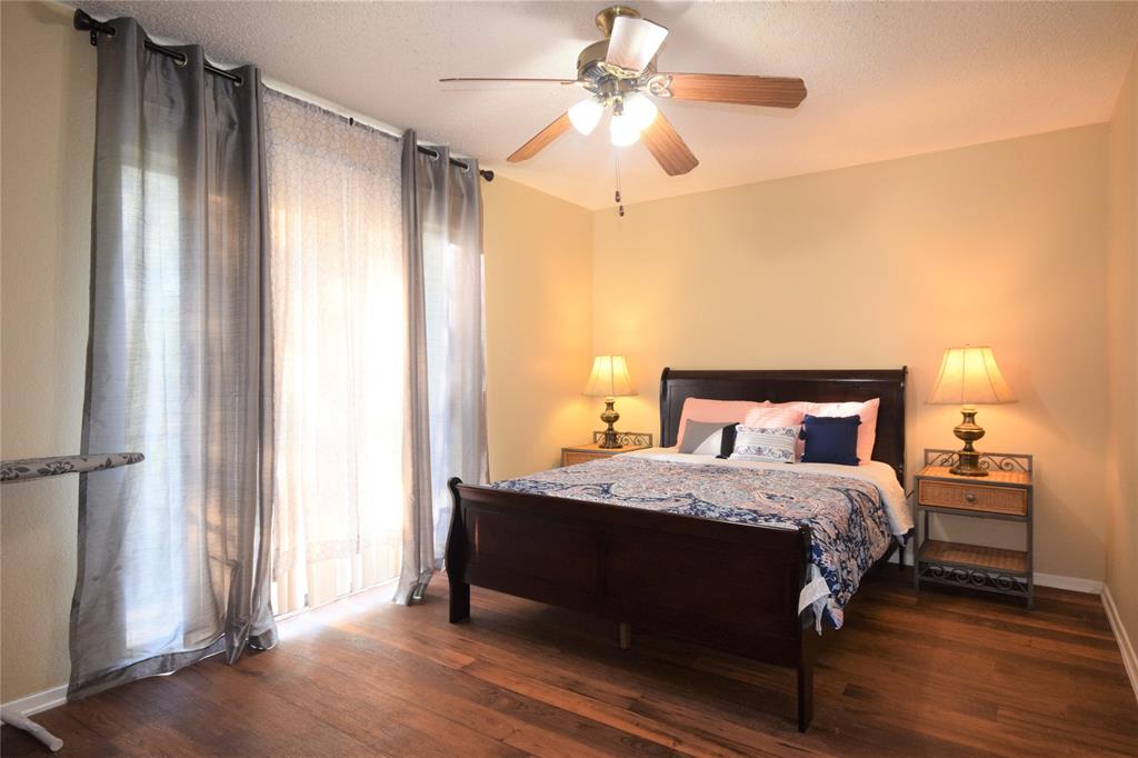 4909 Jamesway Road, Unit 203D Fort Worth, TX 76135 - Photo 9 of 17 a bedroom with a bed and a chandelier