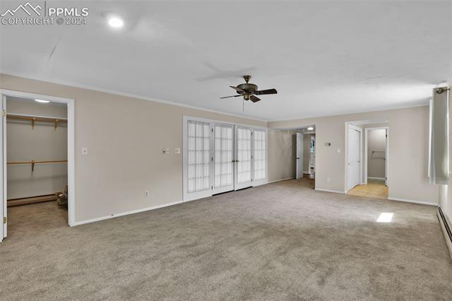 1404 West Cheyenne Road Colorado Springs, CO 80906 - Photo 30 of 50 Unfurnished bedroom with ornamental molding, ceiling fan, light colored carpet, and a spacious closet