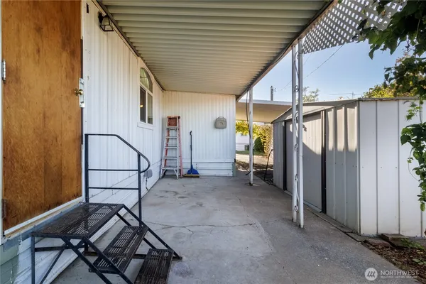 a view of a patio with table and chairs and a barbeque