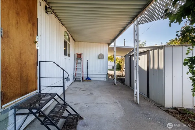 a view of a patio with table and chairs and a barbeque