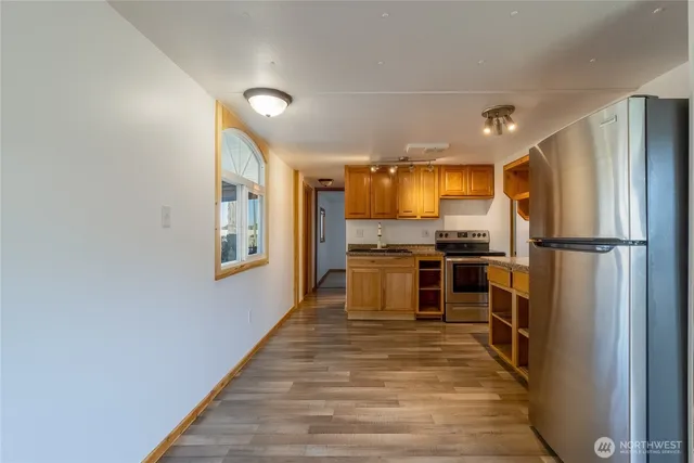 a kitchen with granite countertop a refrigerator and a stove top oven
