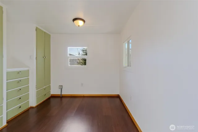 an empty room with wooden floor and closet
