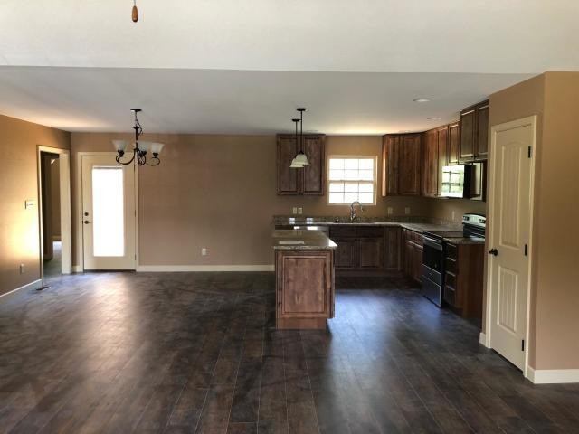 125 Timber Creek Road Maynardville, TN 37807 - Photo 4 of 18 a kitchen with granite countertop a refrigerator a sink dishwasher a stove and white cabinets with wooden floor