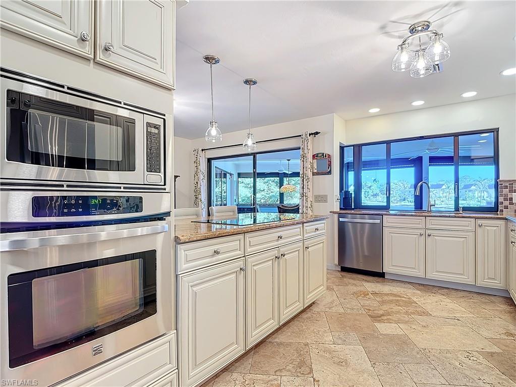 1659 Sandpiper Street, Unit E Naples, FL 34112 - Photo 21 of 50 a kitchen with stainless steel appliances kitchen island granite countertop a stove and white cabinets