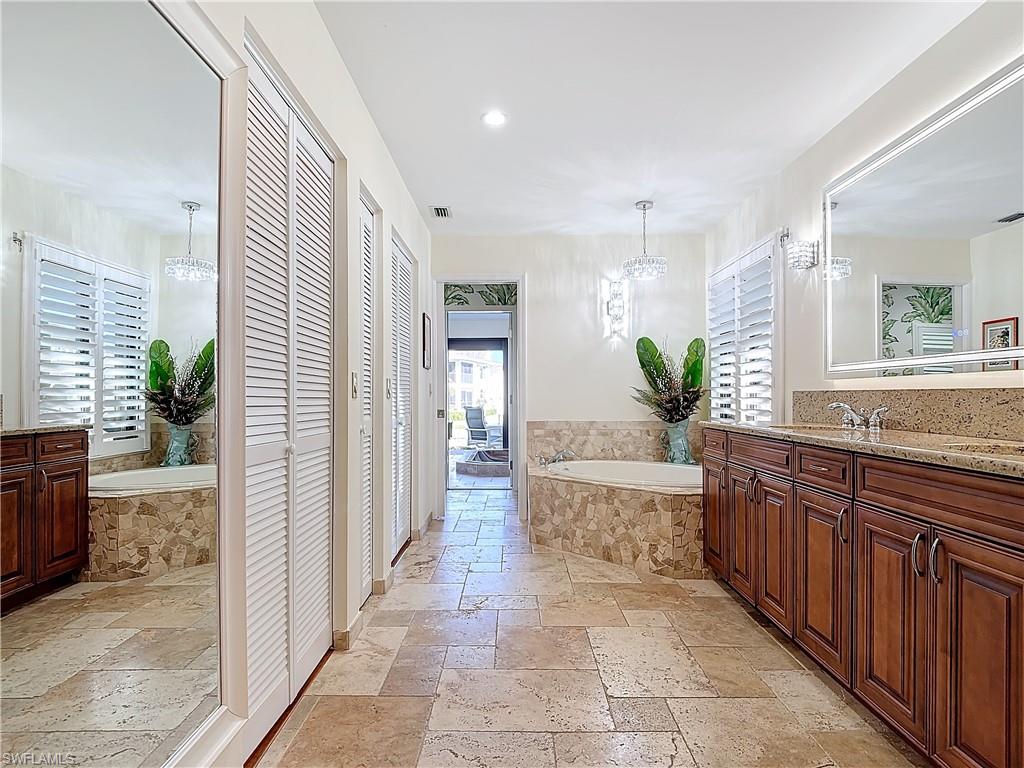 1659 Sandpiper Street, Unit E Naples, FL 34112 - Photo 26 of 50 a large spacious bathroom with a granite countertop tub a mirror and a shower