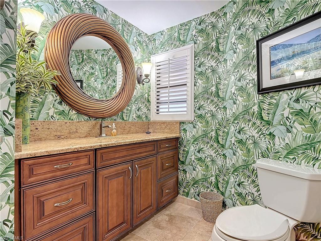 1659 Sandpiper Street, Unit E Naples, FL 34112 - Photo 32 of 50 a bathroom with a toilet a sink and a mirror