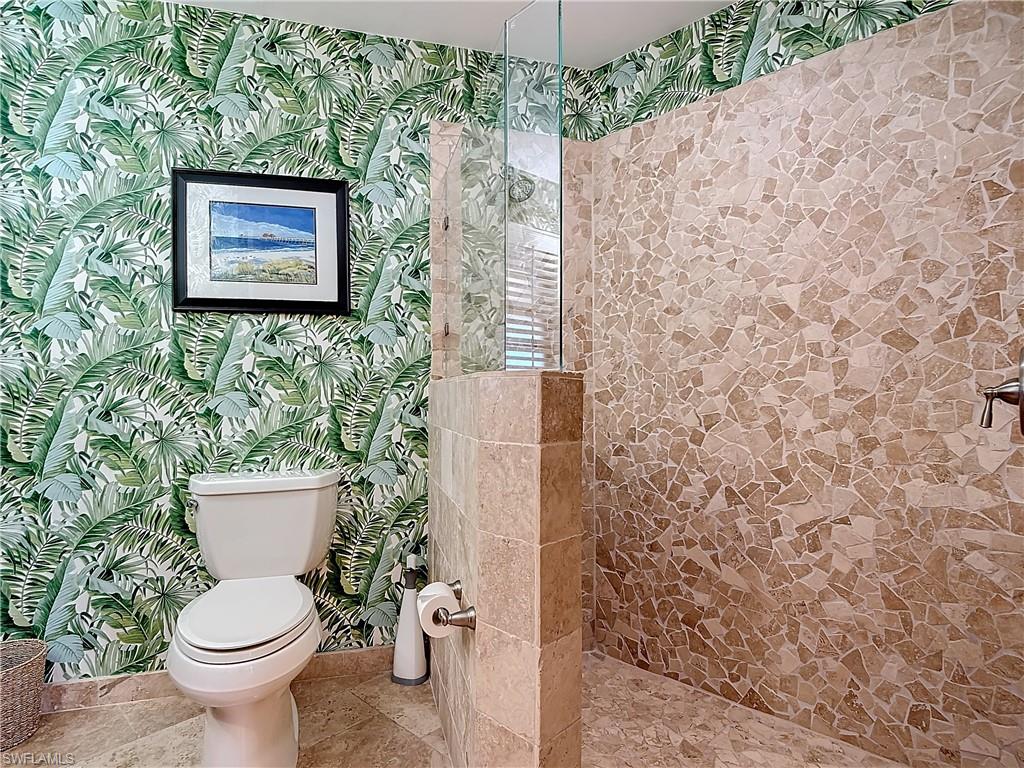 1659 Sandpiper Street, Unit E Naples, FL 34112 - Photo 33 of 50 a white toilet sitting next to a shower curtain