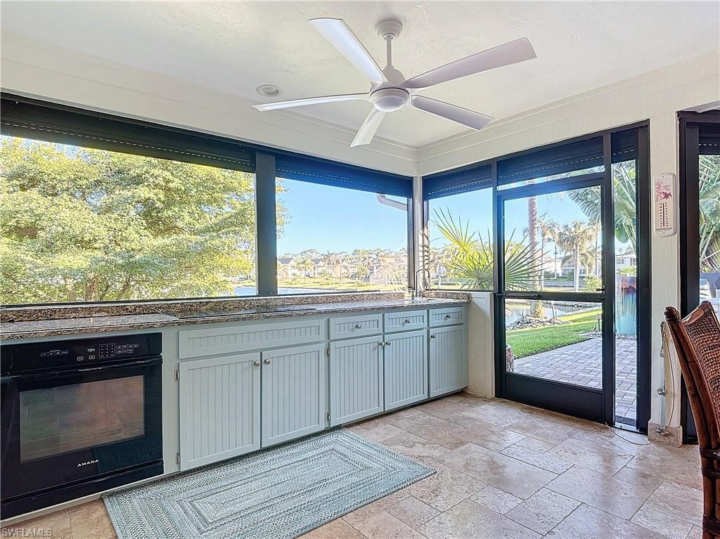 1659 Sandpiper Street, Unit E Naples, FL 34112 - Photo 36 of 50 a kitchen with stainless steel appliances granite countertop a stove a sink and a microwave