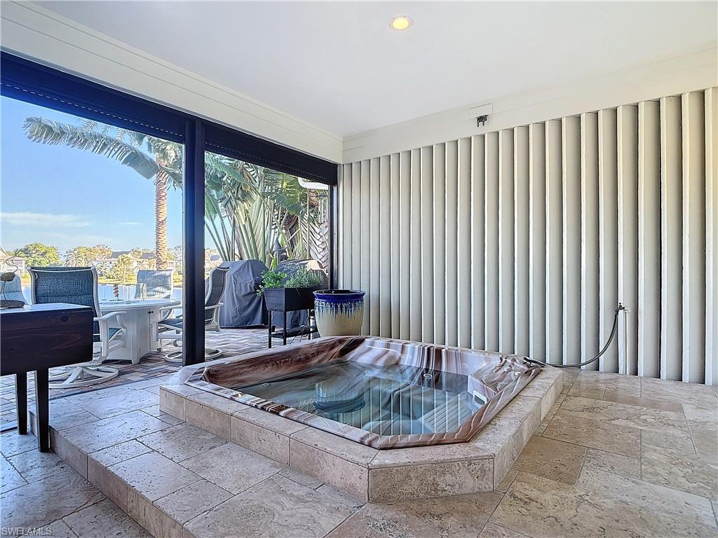 1659 Sandpiper Street, Unit E Naples, FL 34112 - Photo 40 of 50 a living room with furniture and a floor to ceiling window