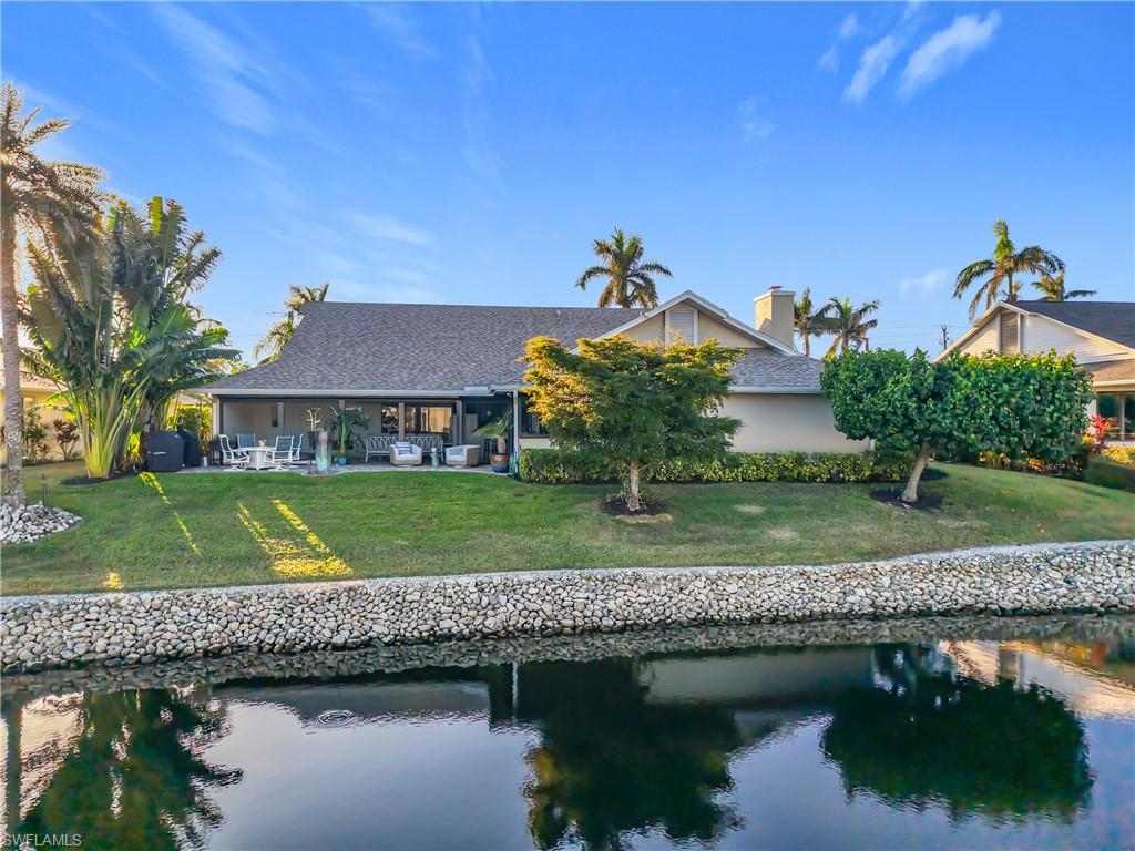 1659 Sandpiper Street, Unit E Naples, FL 34112 - Photo 43 of 50 a view of a house next to a lake with a house