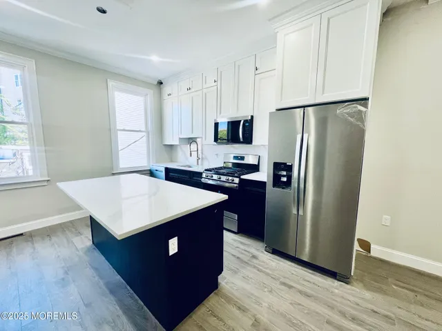 a kitchen with stainless steel appliances a refrigerator sink and cabinets