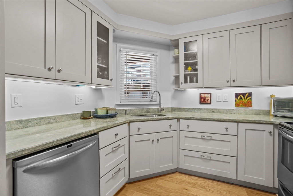 45 Main Street, Unit 112 Wareham, MA 02571 - Photo 10 of 30 a kitchen with granite countertop white cabinets and white appliances