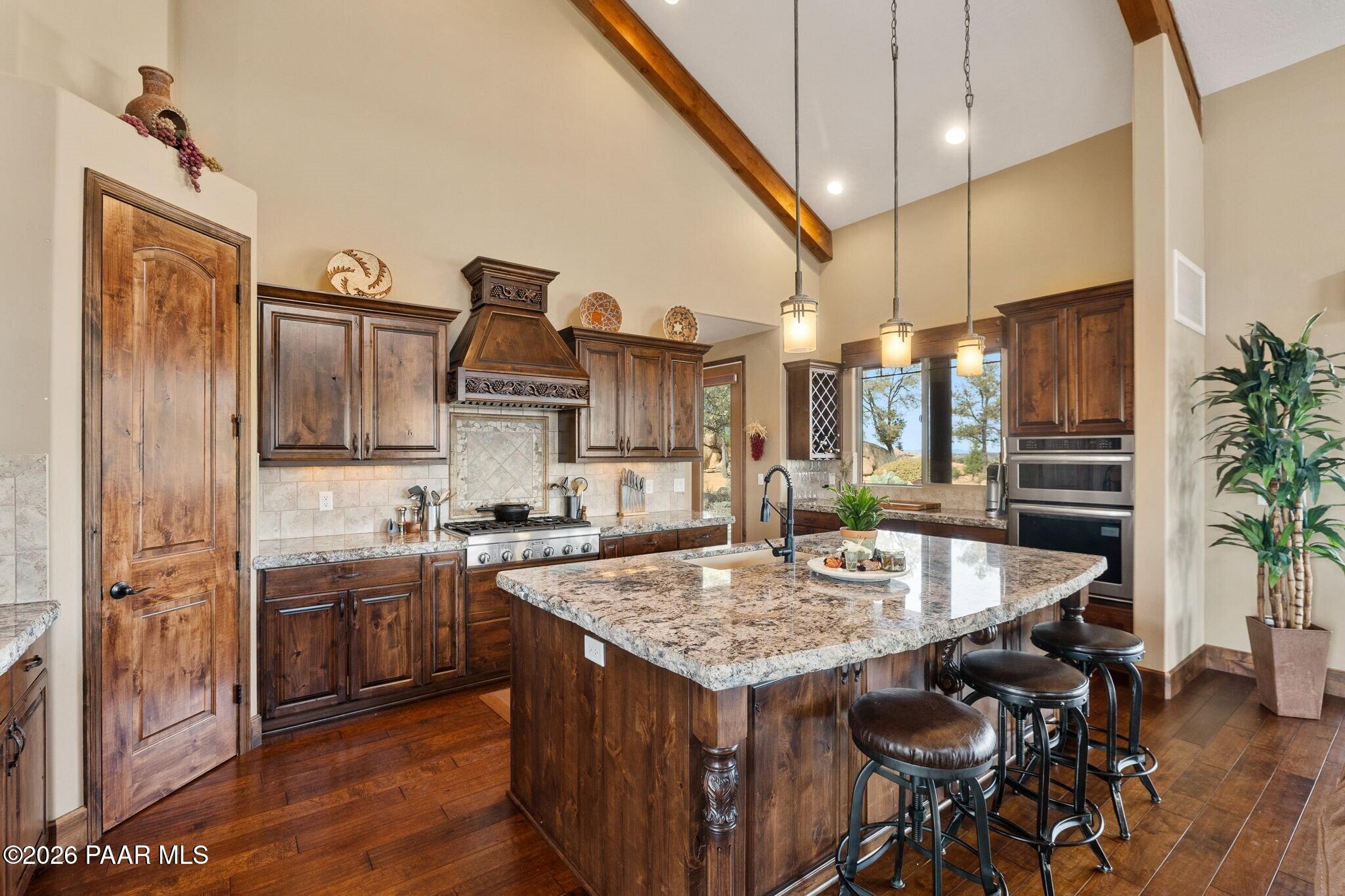 4290 Fort Bridger Road Prescott, AZ 86305 - Photo 12 of 50 a kitchen with stainless steel appliances granite countertop table chairs and wooden floor