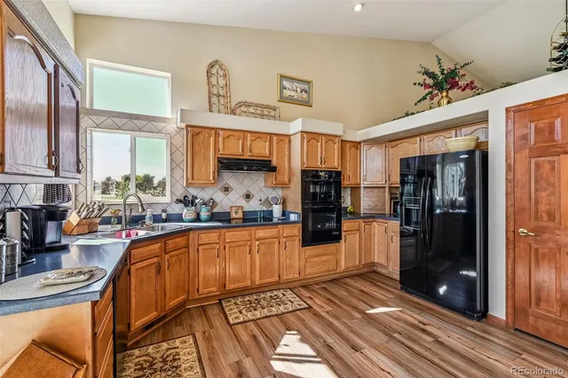 a kitchen with stainless steel appliances granite countertop a stove top oven a sink and cabinets