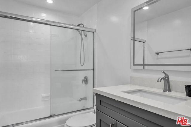 a bathroom with a granite countertop sink toilet and shower