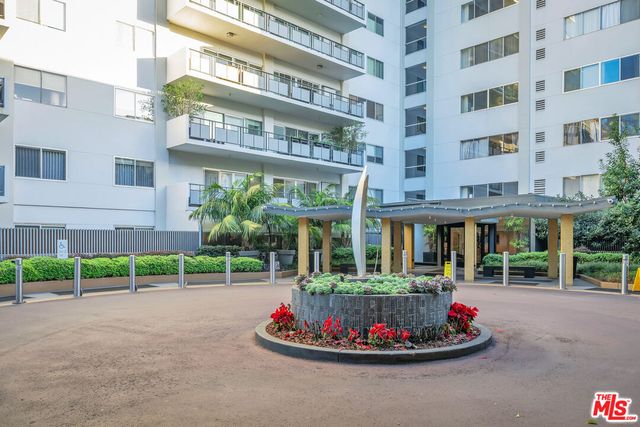 a front view of a building with a garden and plants
