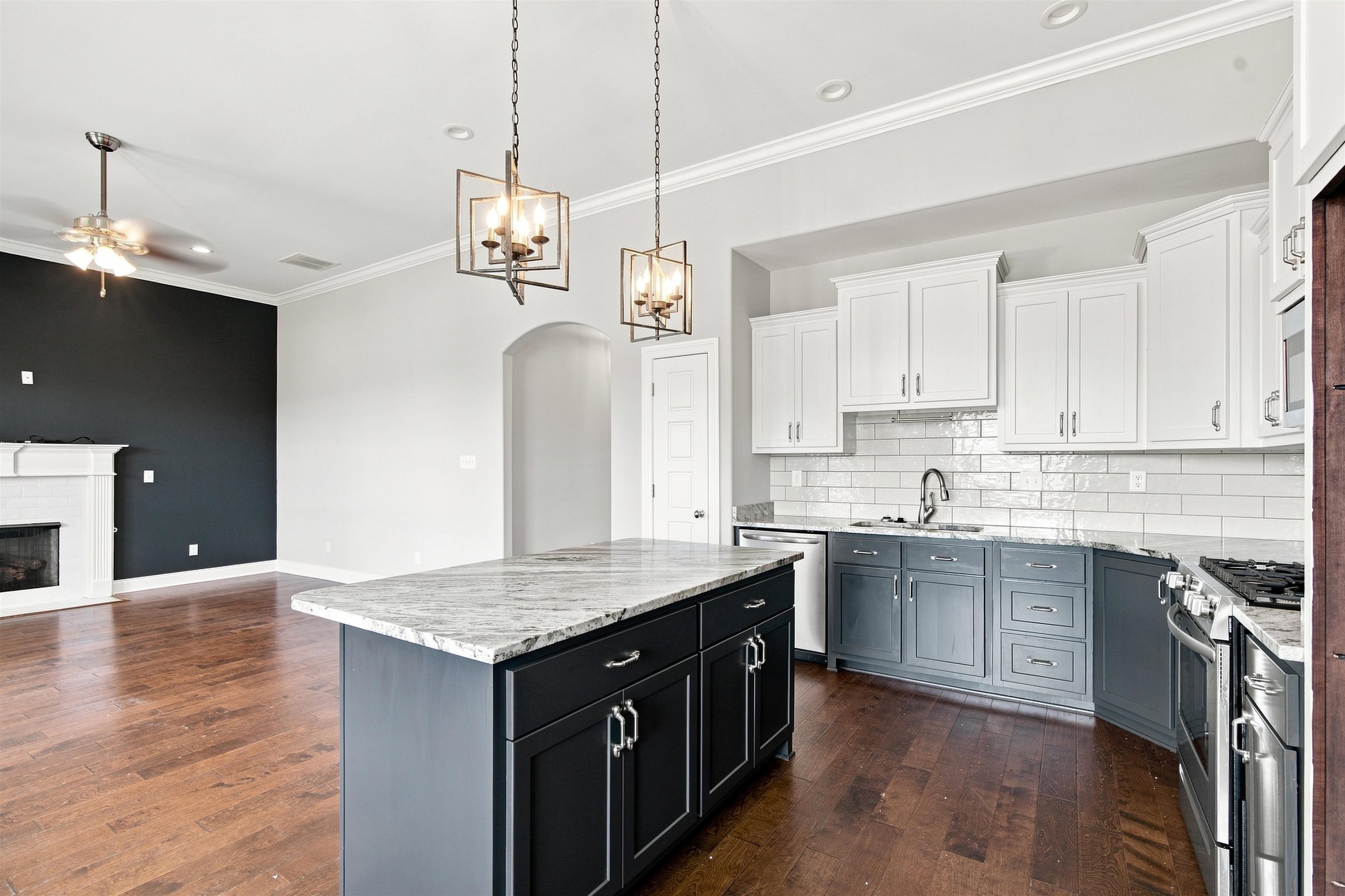 70 Trinity Cove Atoka, TN 38004 - Photo 4 of 19 Two-tone cabinetry with stainless steel appliances, granite countertops, and subway tile backsplash