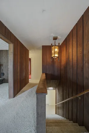 a view of a hallway with wooden floor and staircase
