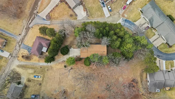 a aerial view of a house with a yard and green space