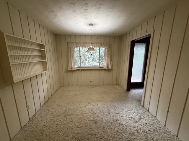 a view of an empty room with a fireplace and a window