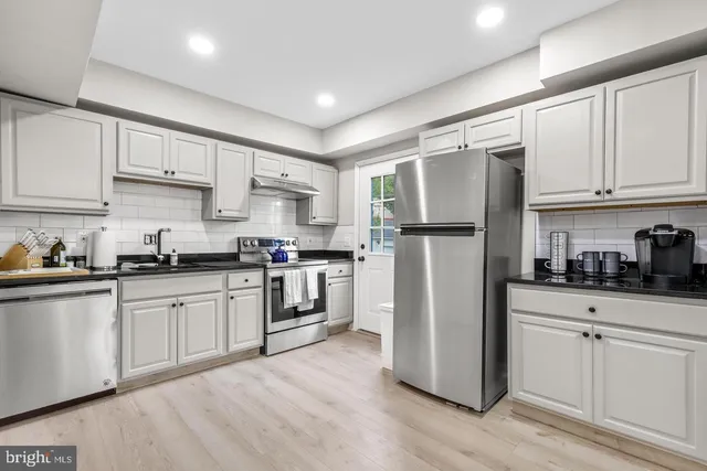 a kitchen with stainless steel appliances granite countertop a refrigerator sink and cabinets