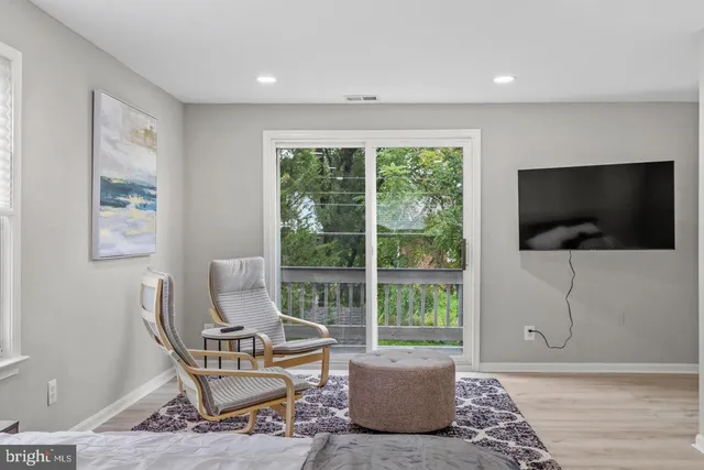 a living room with a flat screen tv and a floor to ceiling window