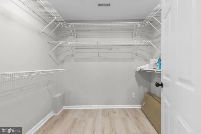 a view of walk in closet with empty racks
