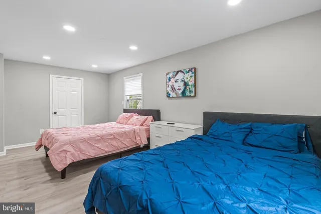 a bedroom with two beds and a painting on the wall