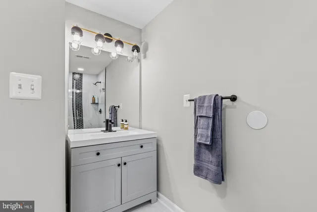 a bathroom with a sink vanity and mirror