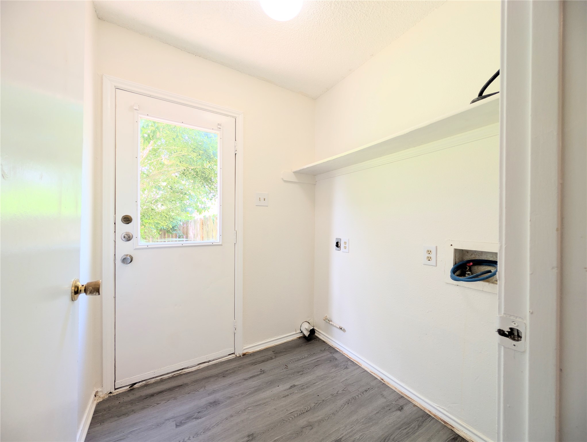 2036 Redwing Way Round Rock, TX 78664 - Photo 11 of 23 Functional laundry space with a convenient exterior door and practical shelving.