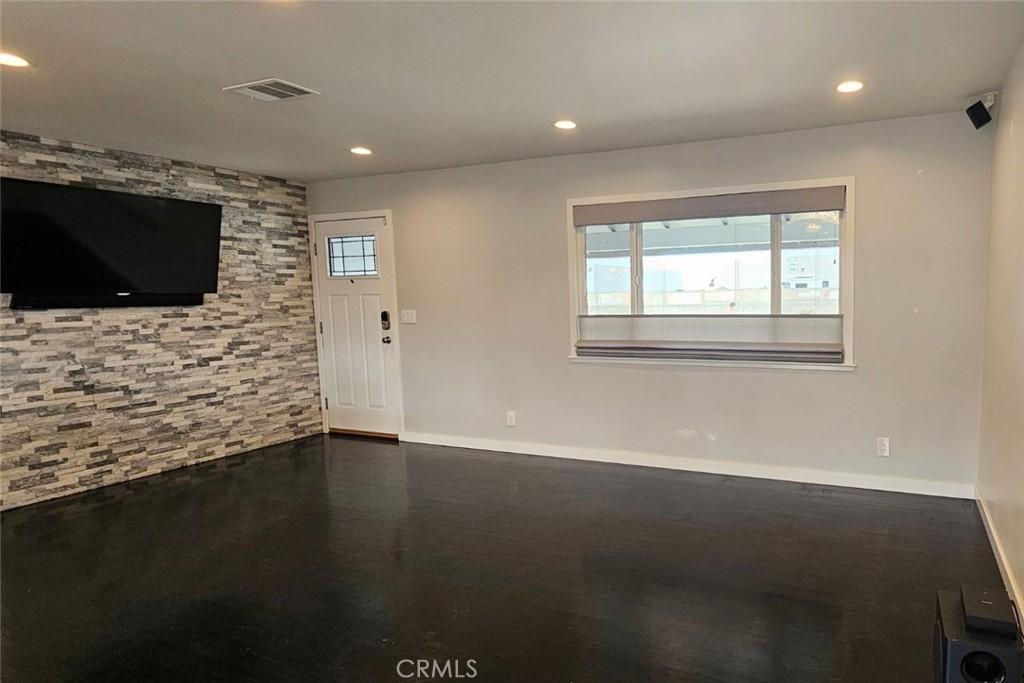 5352 Edinger Avenue Huntington Beach, CA 92649 - Photo 2 of 17 a view of an empty room with wooden floor and a window