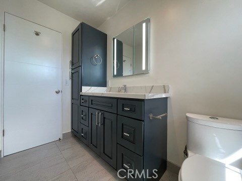 5352 Edinger Avenue Huntington Beach, CA 92649 - Photo 9 of 17 a bathroom with a granite countertop toilet sink and mirror